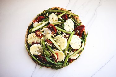 Asparagus, Sun-dried Tomato, Pesto and Arugula Pizza ready for baking.