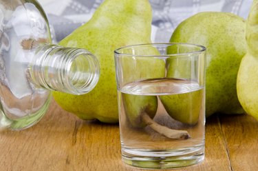 fruit brandy in a glass and fresh pears