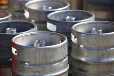 Lots of metal barrels at a beer factory