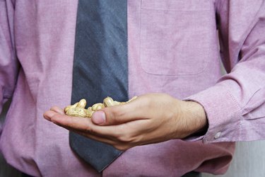 A businessman holding peanuts in his hand