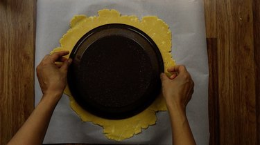 Putting gluten-free, low-carb coconut flour rolled pie crust into pie pan.