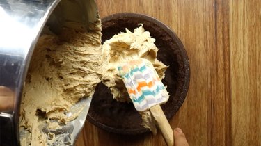 Pouring filling for no-bake peanut butter cream cheese pie into prepared pie crust.