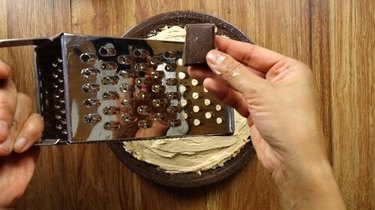 Grating sugar-free semi-sweet chocolate over peanut butter cream cheese pie.