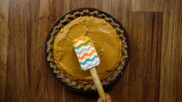 Smoothing the top of the filling on an unbaked low carb gluten free pumpkin pie.