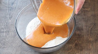 Pouring pumpkin mixture into dry ingredients.