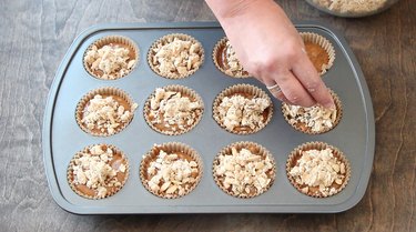 Topping muffin batter with streusel.