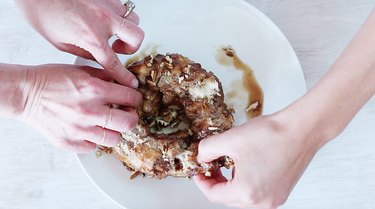 Pulling rolls apart from finished monkey bread.