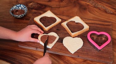 spreading chocolate filling onto bread