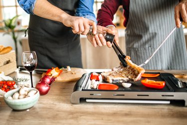 Grilling t-bone steak and adding ingredients for better taste.