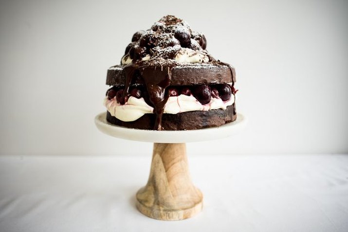 A two-layered black forest cake with a poached cherry and cream filling.