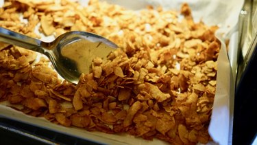 Baking coconut chips to make coconut bacon.