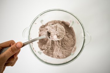 Checking the crumb mixture consistency with a spoon.