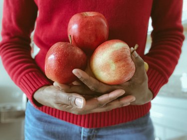 Midsection of Woman Holding Handful of Apples