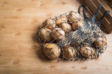 Everyday shopping with reusable mesh bag and raw potatoes