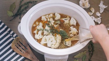 Pouring broth into crockpot