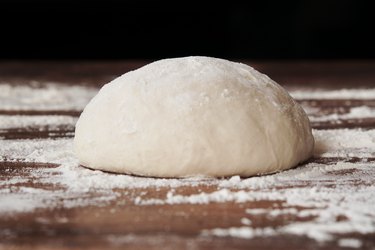 Dough ball on floured wooden table