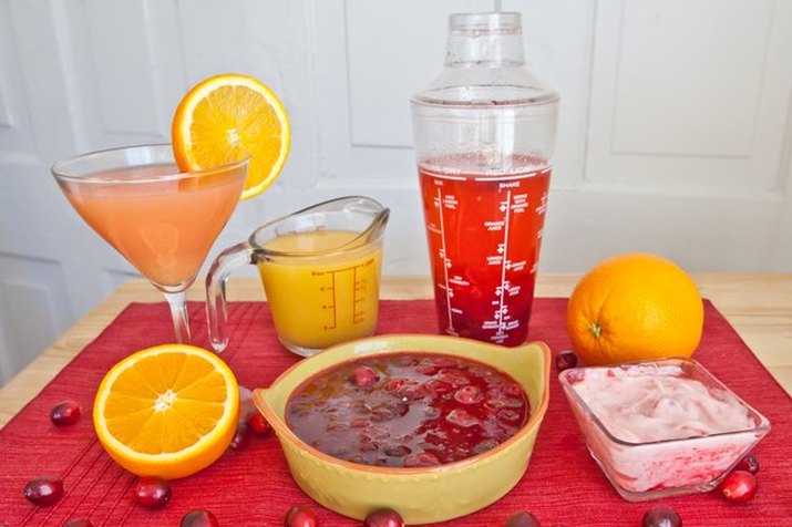 Homemade cranberry sauce in a bowl, surrounded by alternative ingredients and cranberry-based preparations