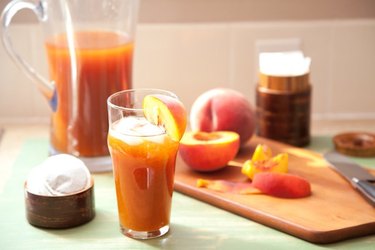 Glass and pitcher of peach tea.