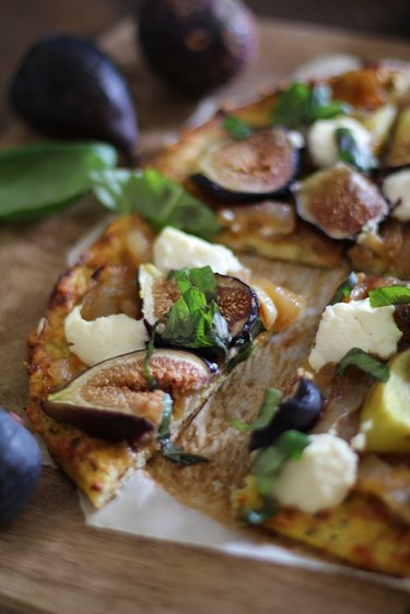 Cauliflower crust pizza with toppings, cut for serving.