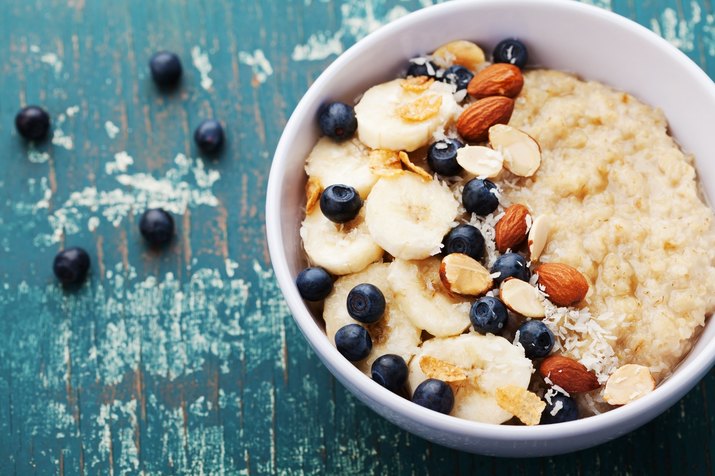 Bowl of homemade oatmeal porridge with banana, blueberries and almonds