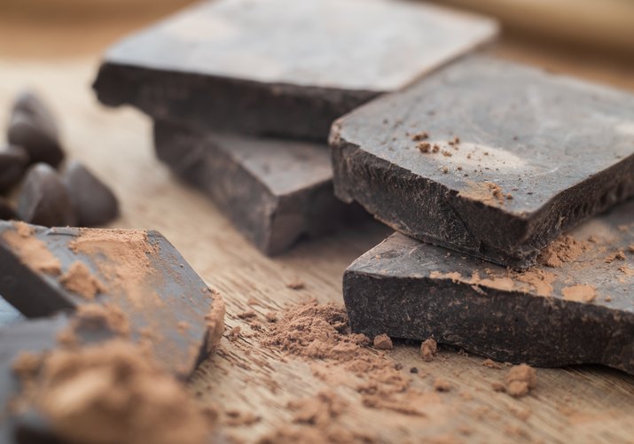 Dark chocolate with cocoa on wooden table