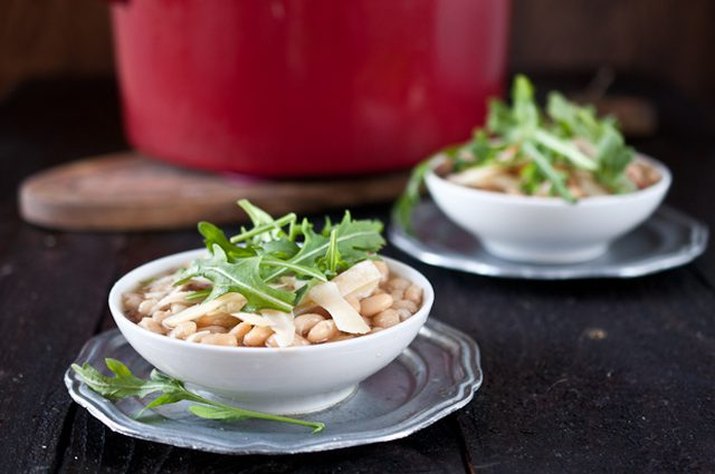 Slow cooker white bean beer and ham soup served with arugula