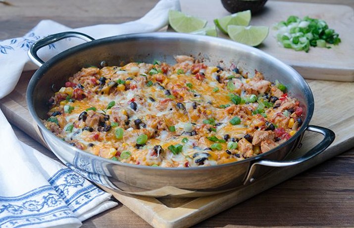 Tex-Mex chicken and rice skillet served with lime wedges and cilantro