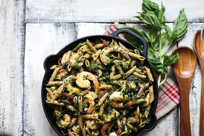 Whole wheat shrimp pesto with basil in a cast iron skillet