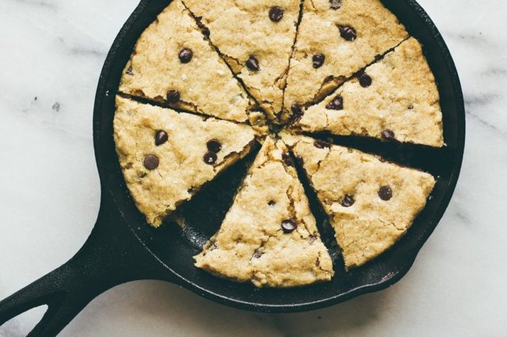 A black cast iron skilled with a giant cookie cooked on it