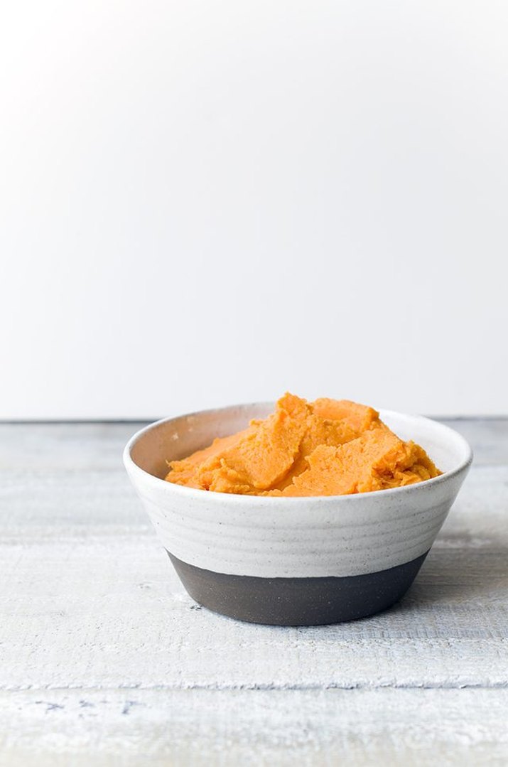 A bowl of creamy, orange mashed sweet potatoes.