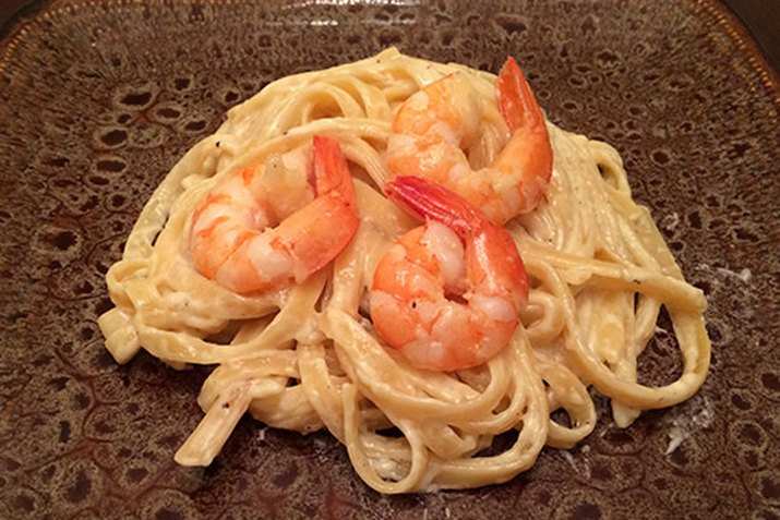 Shrimp on a bed of creamy fettuccine Alfredo.